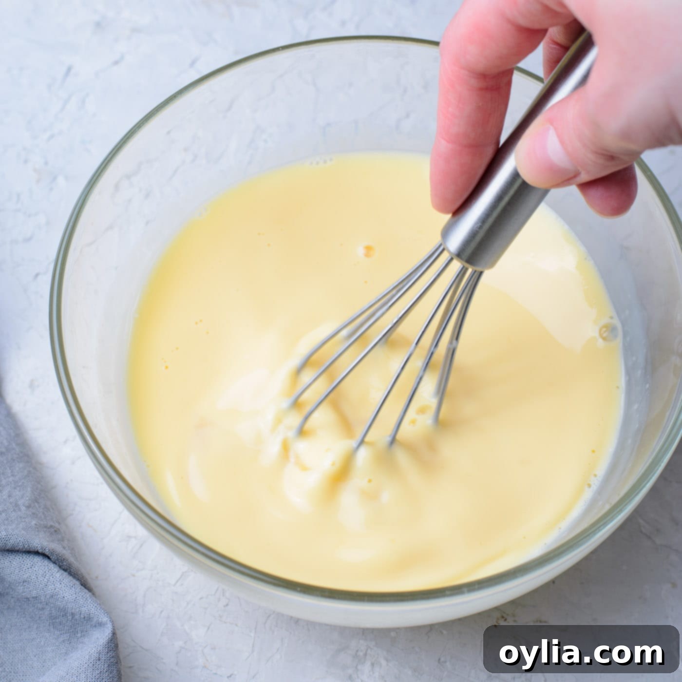 eggs, vanilla, milk, and butter whisked in a bowl