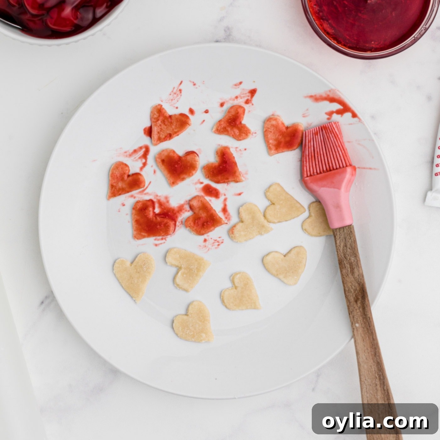 brushing heart pie dough with red food color