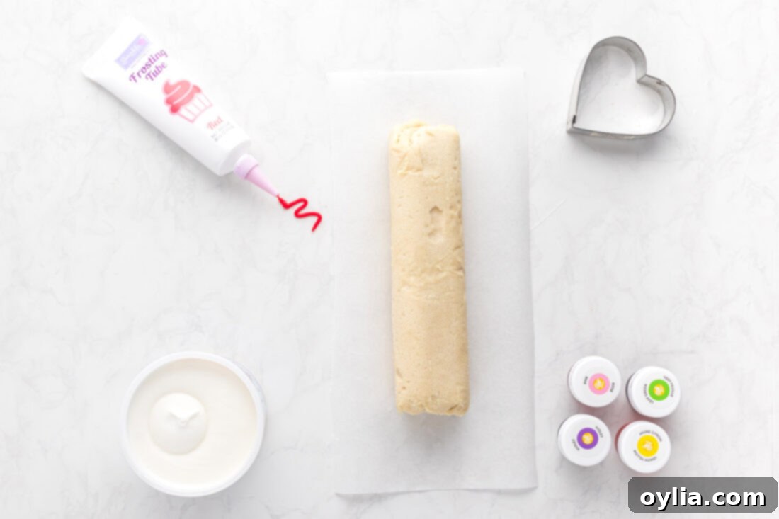 Sweet Talk Cookies 4 A vibrant display of ingredients including cookie dough, white frosting, various gel food colors, and a red icing tube, all ready to make Conversation Heart Cookies.