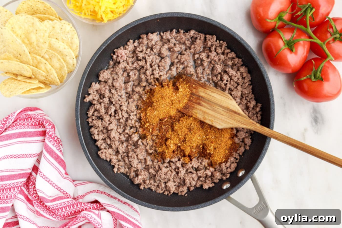 browning ground beef in skillet with taco seasoning, showing the seasoned meat mixture