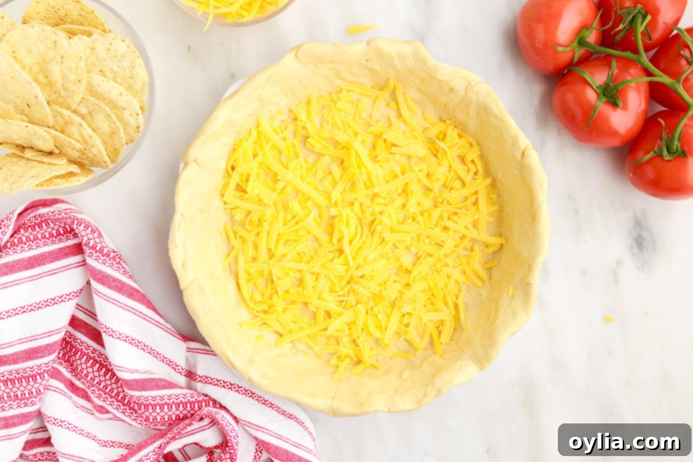 a layer of shredded cheese sprinkled over the crescent roll crust in a pie plate