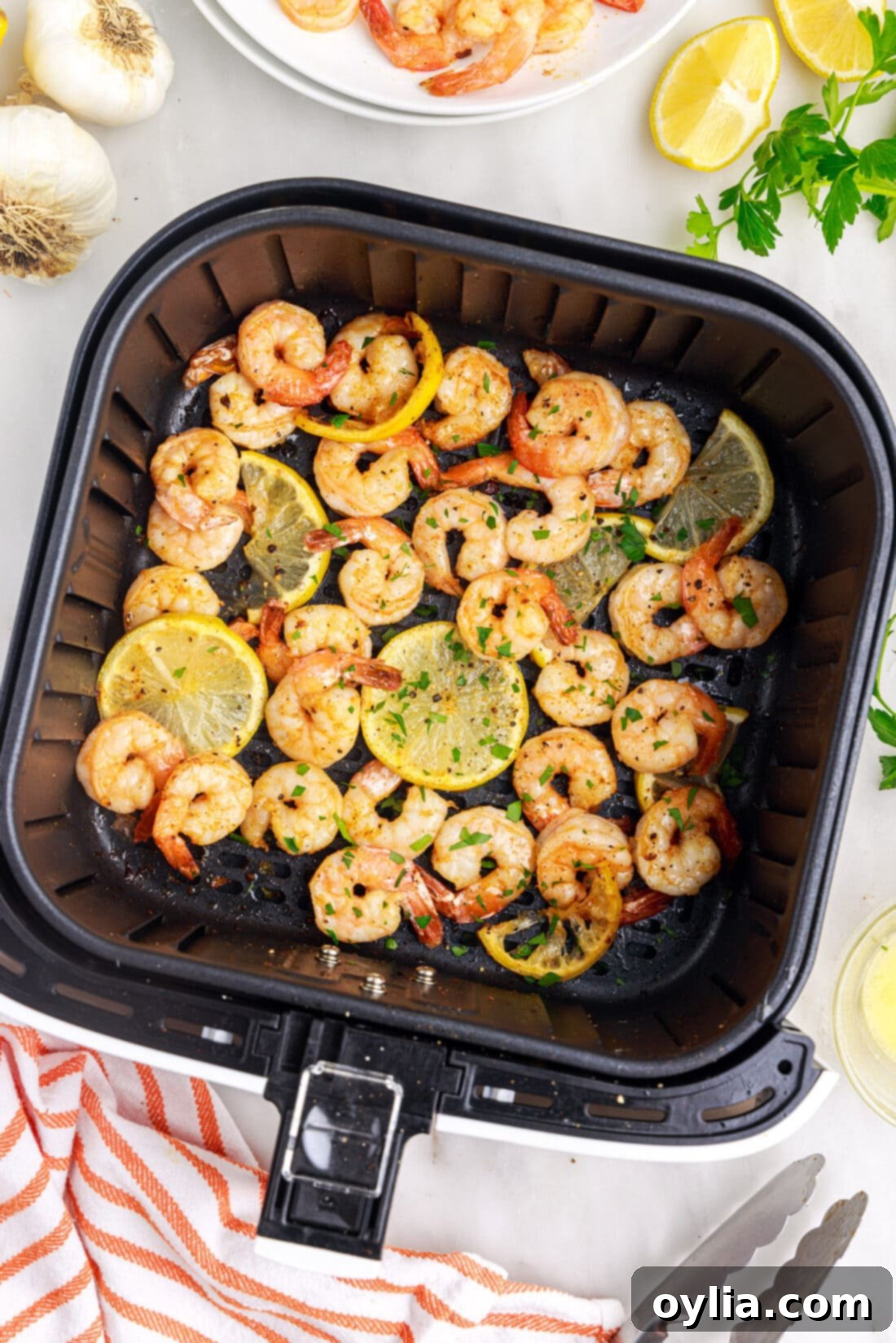Close-up of golden brown air fryer shrimp in an air fryer basket, showing crispy edges and perfect curl.
