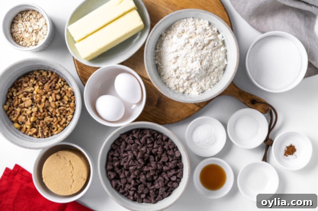 A selection of ingredients laid out, including butter, sugars, flour, eggs, chocolate chips, rolled oats, and walnuts for Doubletree Chocolate Chip Cookies