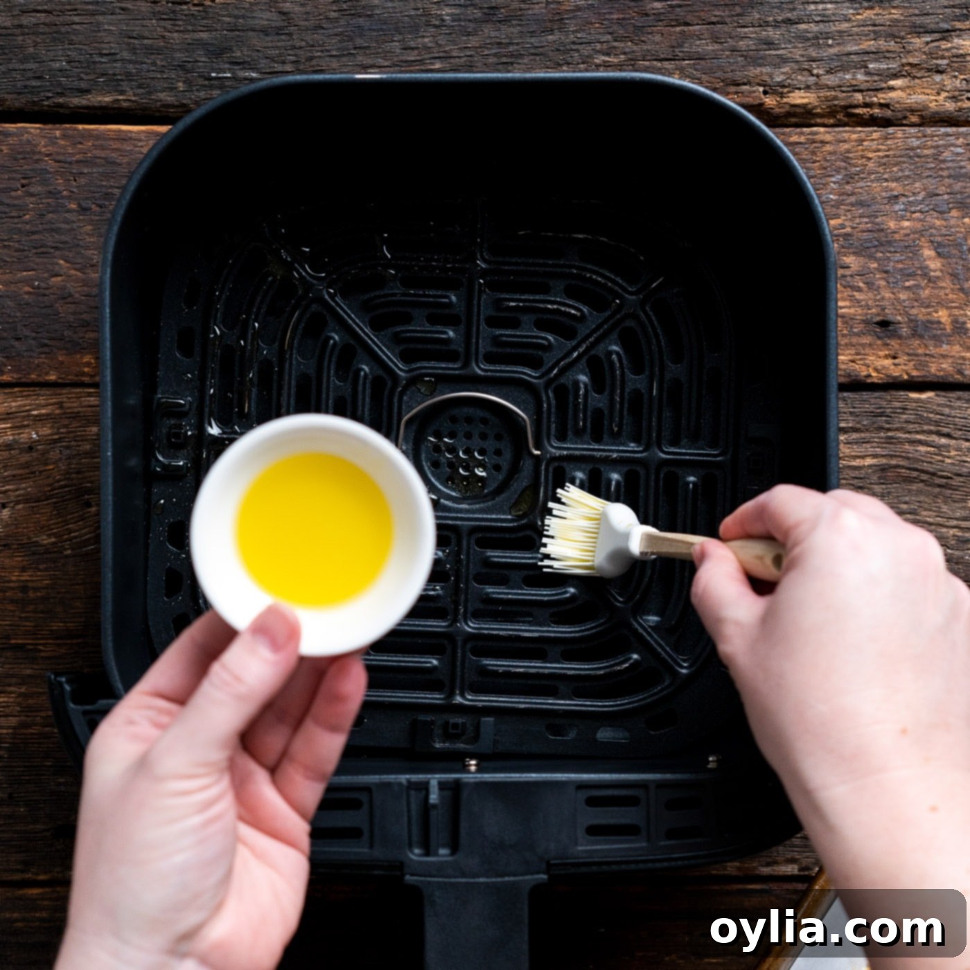 brushing air fryer with olive oil