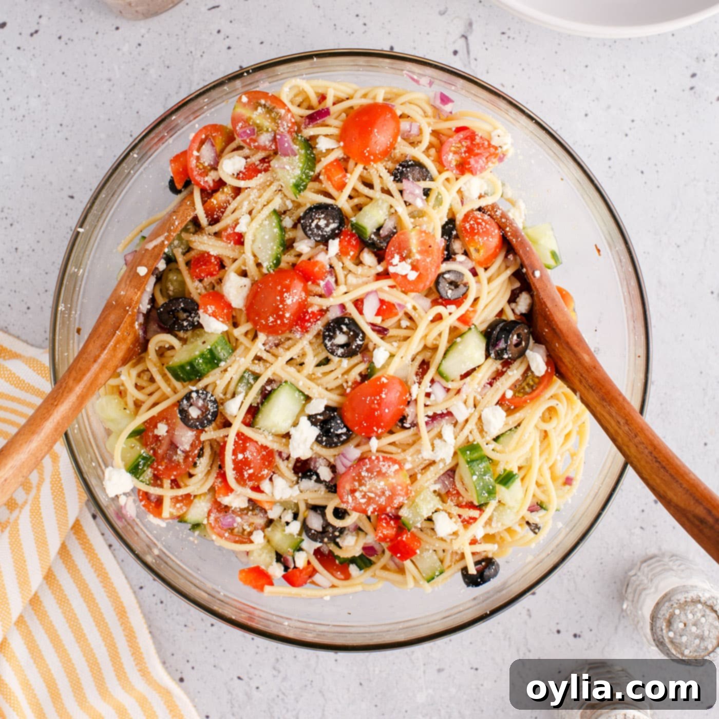 spaghetti salad in a bowl with wooden spoons