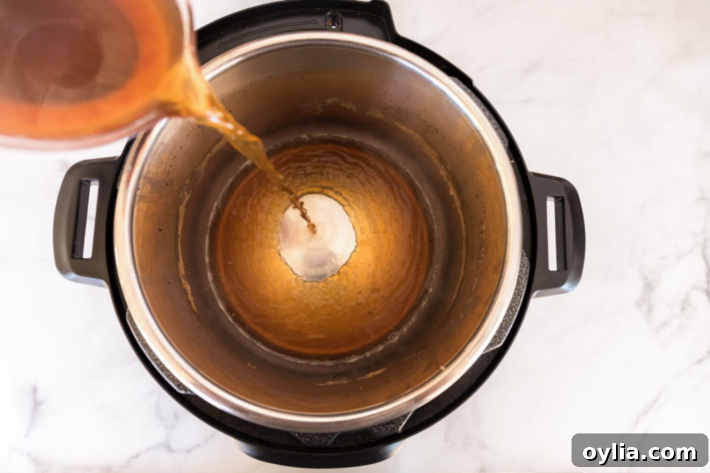 Flavorful liquid being poured back into the Instant Pot for cooking vegetables