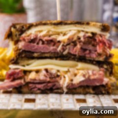 Close up photo of a Reuben Sandwich cut in half stacked on top of each other