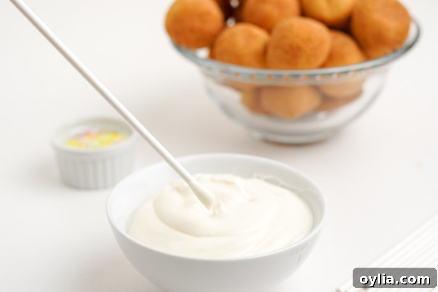 melted white chocolate in a bowl with cake pop stick