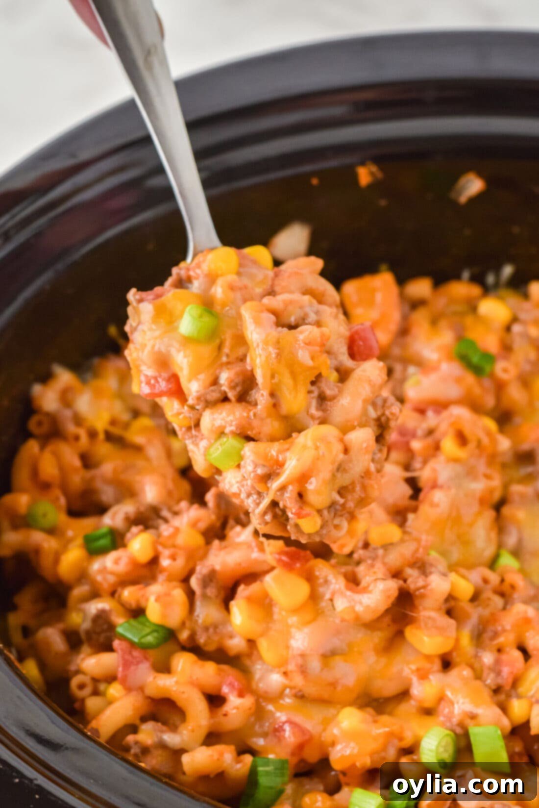 serving spoon lifting a portion of Crockpot Ground Beef Casserole from the pot