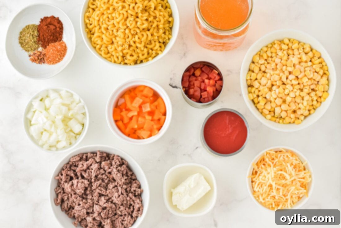 ingredients for Crockpot Ground Beef Casserole laid out on a counter: ground beef, corn, pasta, onions, peppers, cheese, and spices