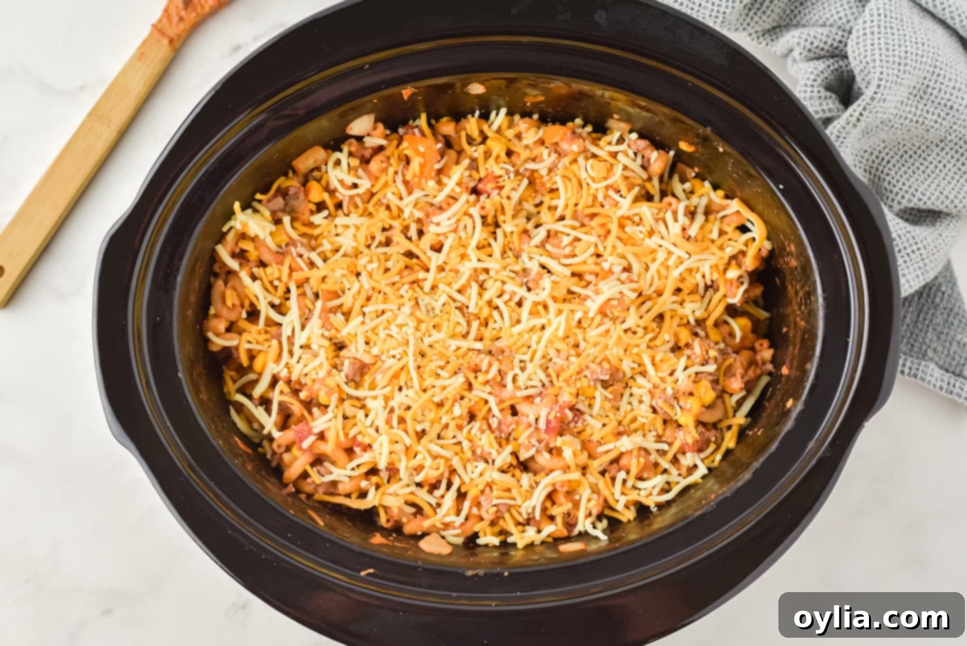 melted cheese on top of ground beef casserole in crockpot, ready to serve