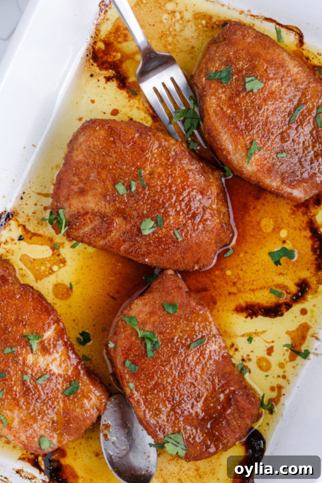 Baked Pork Chops sizzling in a pan straight from the oven