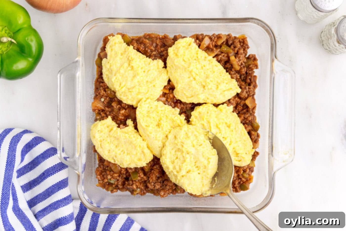 cornbread mixture over sloppy joe meat in a baking dish