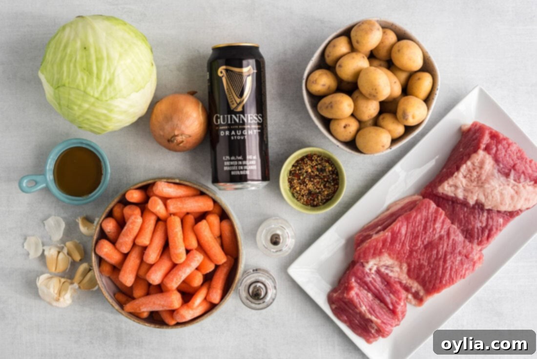 A selection of ingredients for crockpot corned beef: corned beef brisket, onions, carrots, potatoes, cabbage, Guinness beer, honey, and garlic cloves