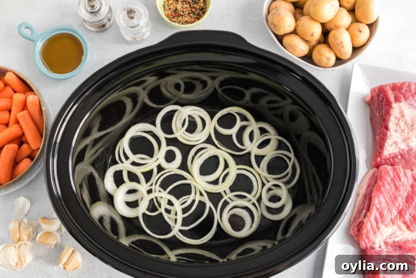 Sliced onions covering the bottom of a crockpot
