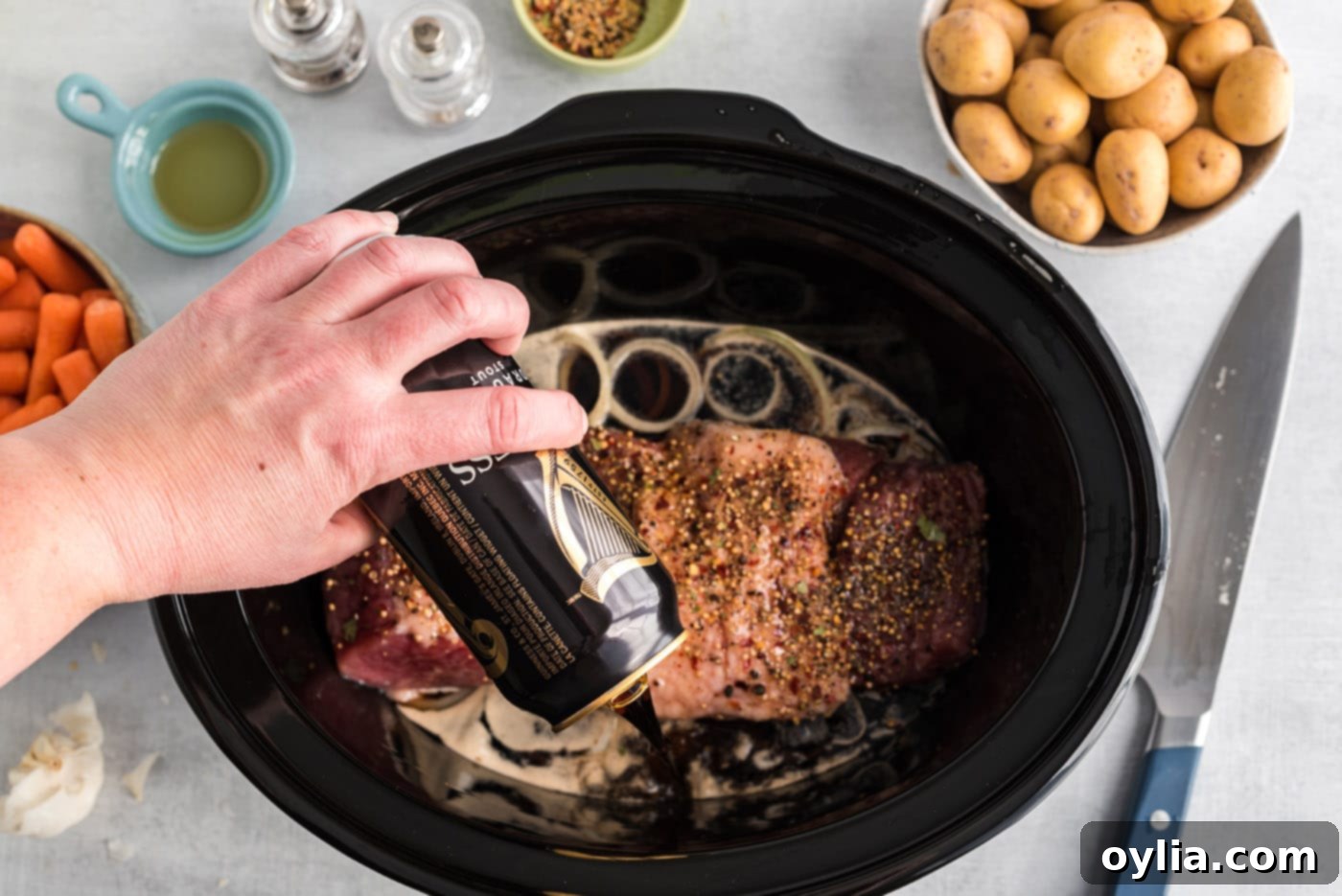 Pouring Guinness beer around the corned beef in the crockpot