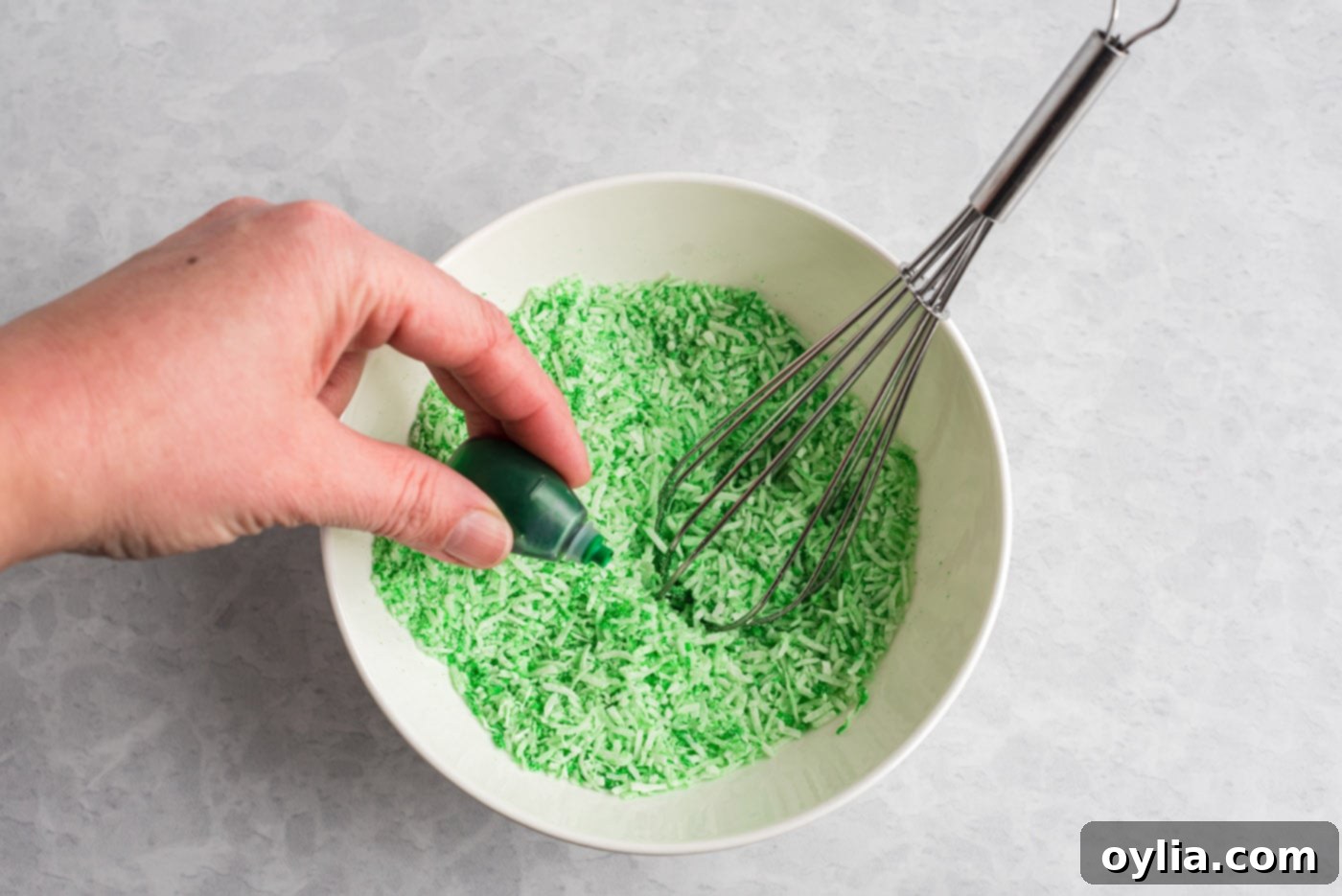 mixing green food coloring with shredded coconut