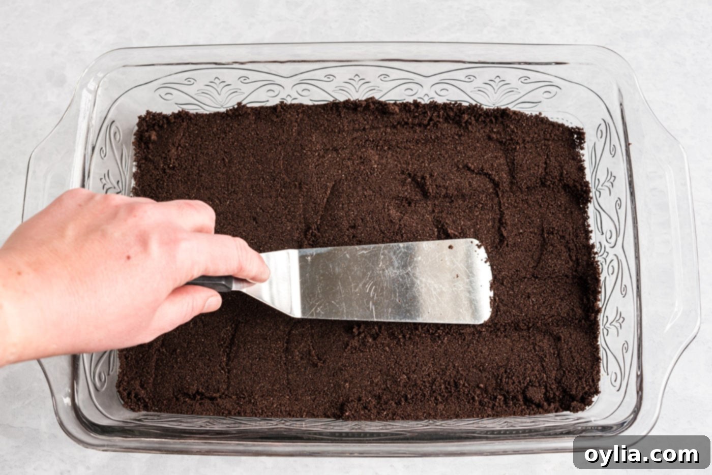 pressing oreo crumbs into a 13x9 baking dish