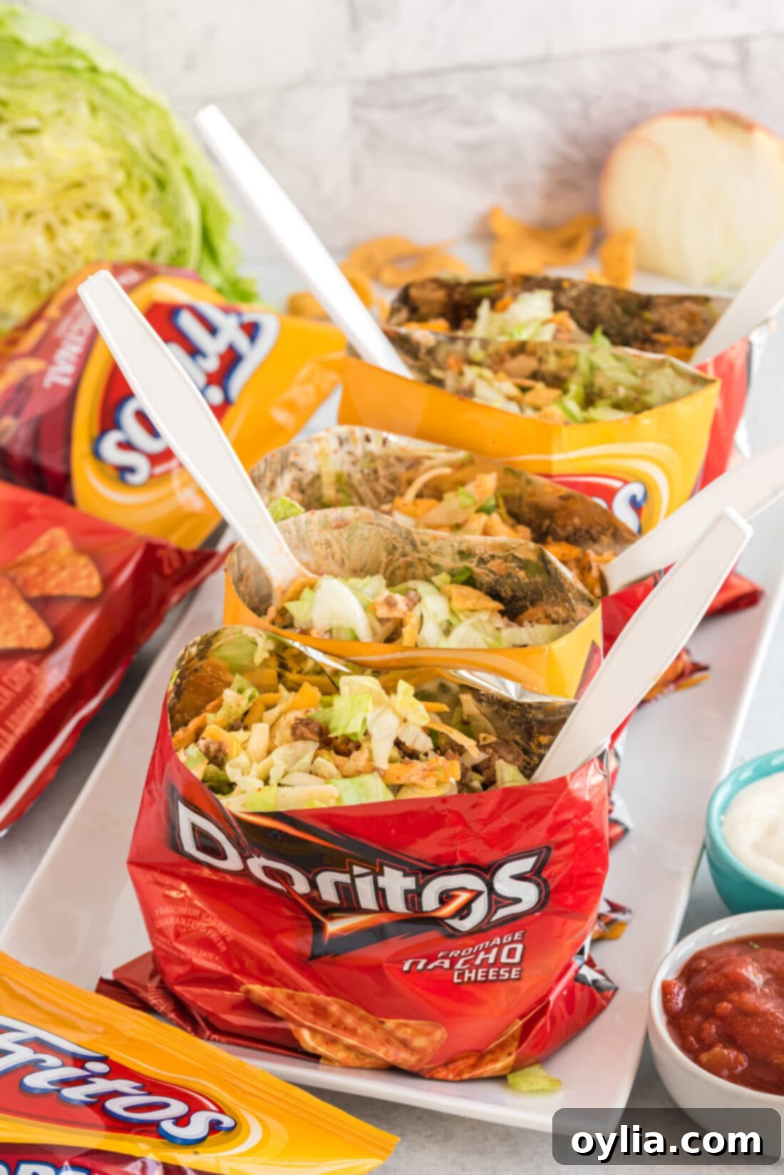 A close-up shot of Walking Tacos served in individual Doritos and Fritos bags.