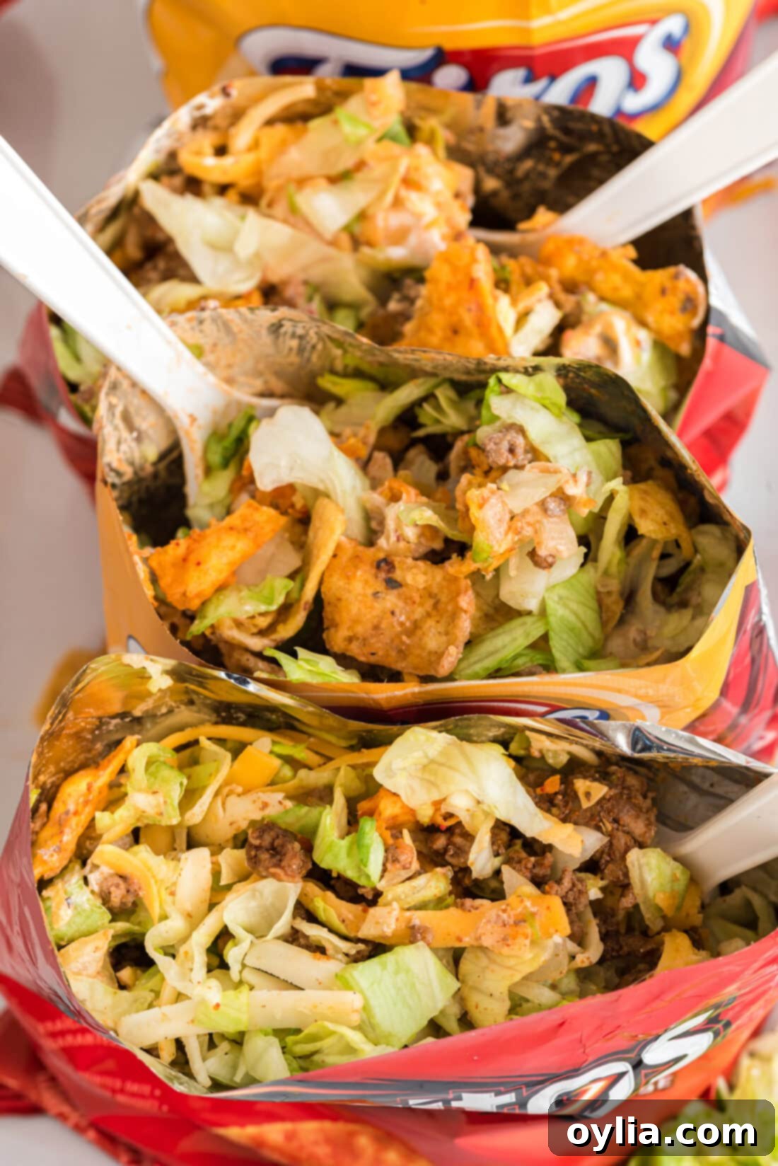 The delicious contents inside several Walking Taco bags, showing meat, chips, and various colorful toppings.