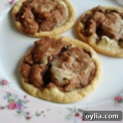 A close up photo of three double stack chocolate chip cookies resting on a plate.