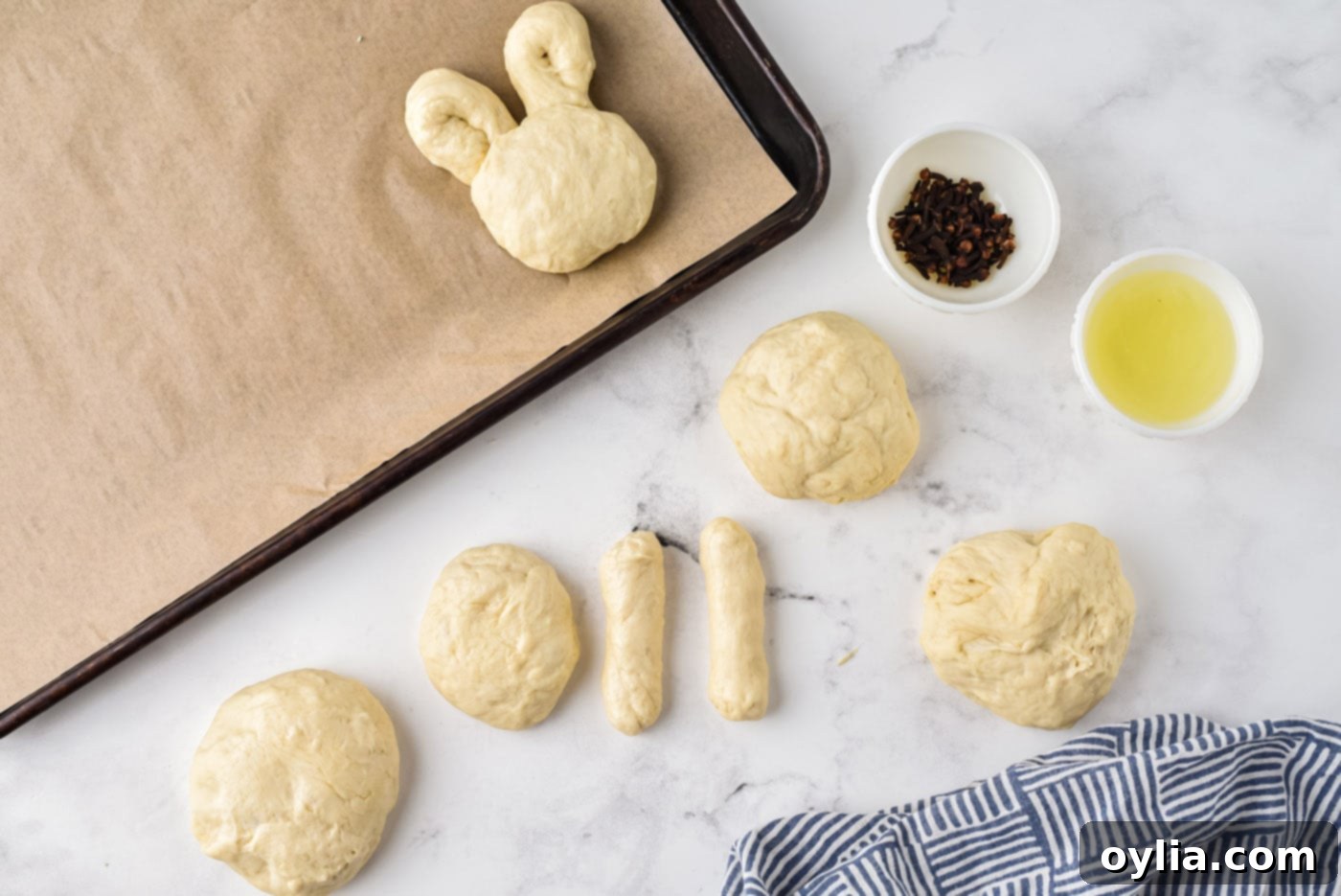 Dough balls divided, one half placed on parchment paper for the bunny head.