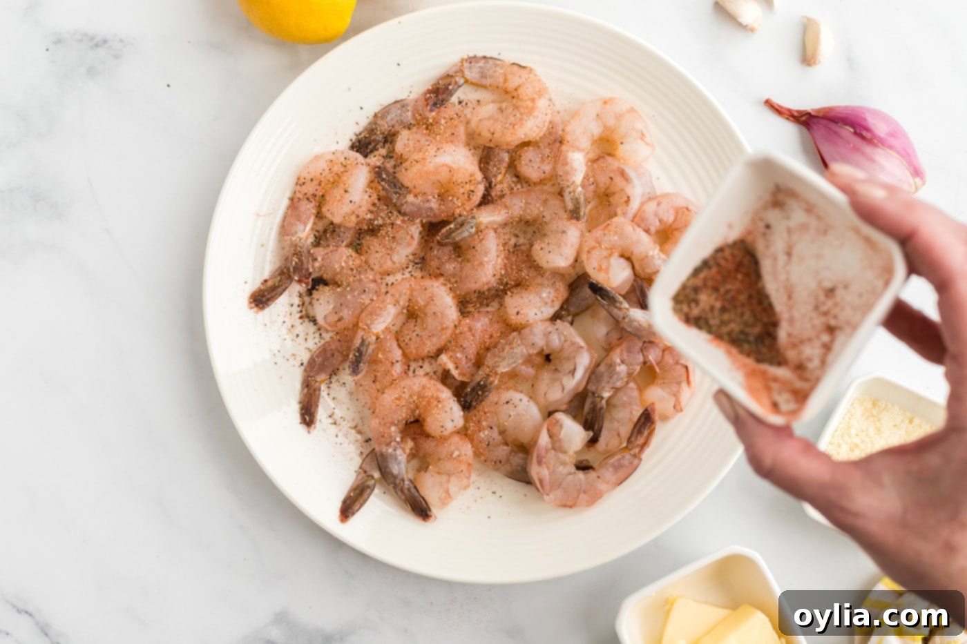 raw shrimp being seasoned in a bowl