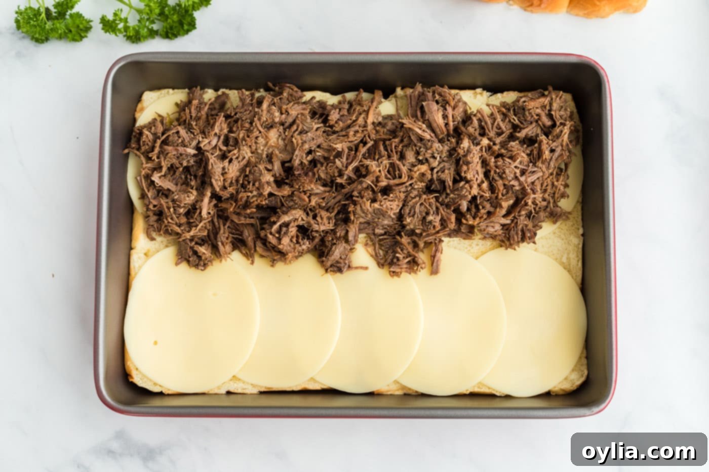 pot roast on top of provolone cheese and hawaiian rolls