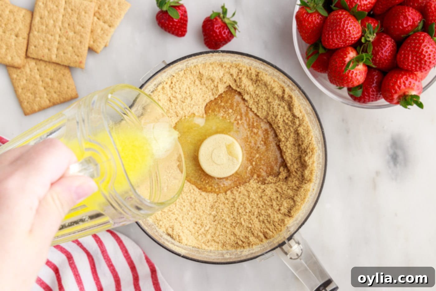 pouring melted butter over graham cracker crumbs