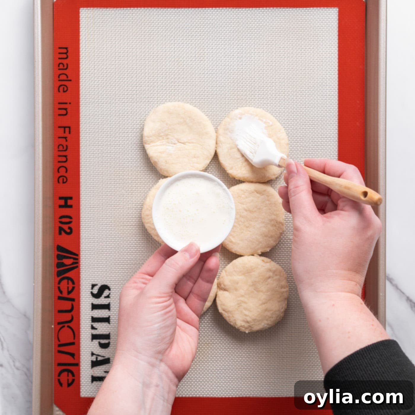 brushing biscuit dough with cream