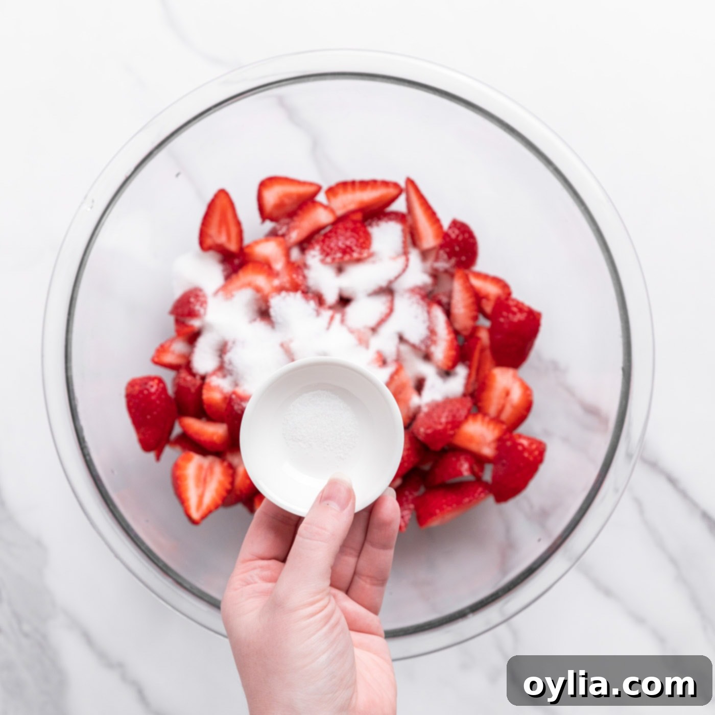 sprinkled sugar on top of chopped strawberries
