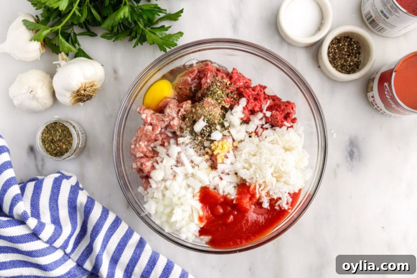 ground beef and sausage in a bowl with seasonings, egg, and rice