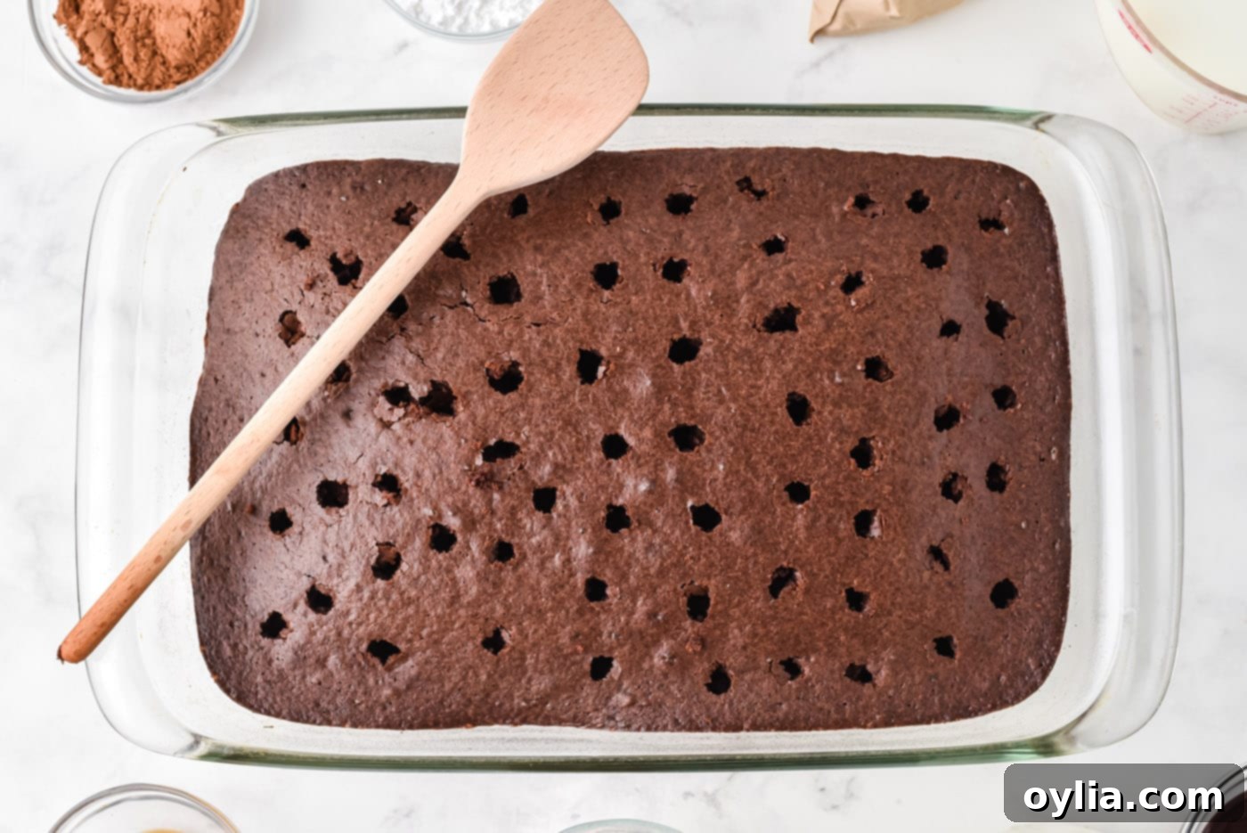 holes poked evenly in a hot chocolate cake with a wooden spoon