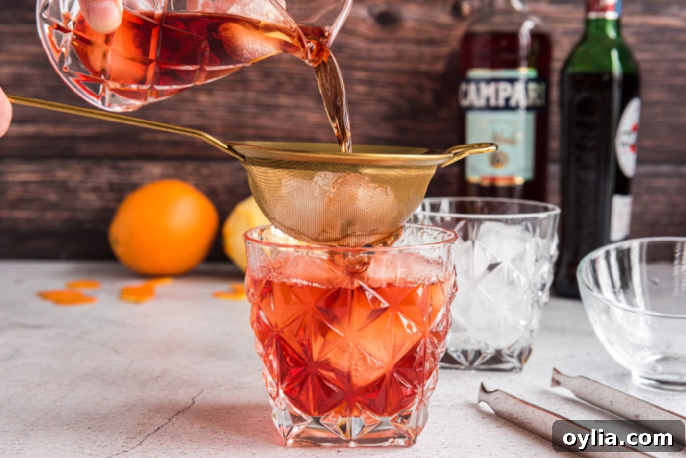 The Italian Standard 6 straining ingredients for Negroni into a rock glass