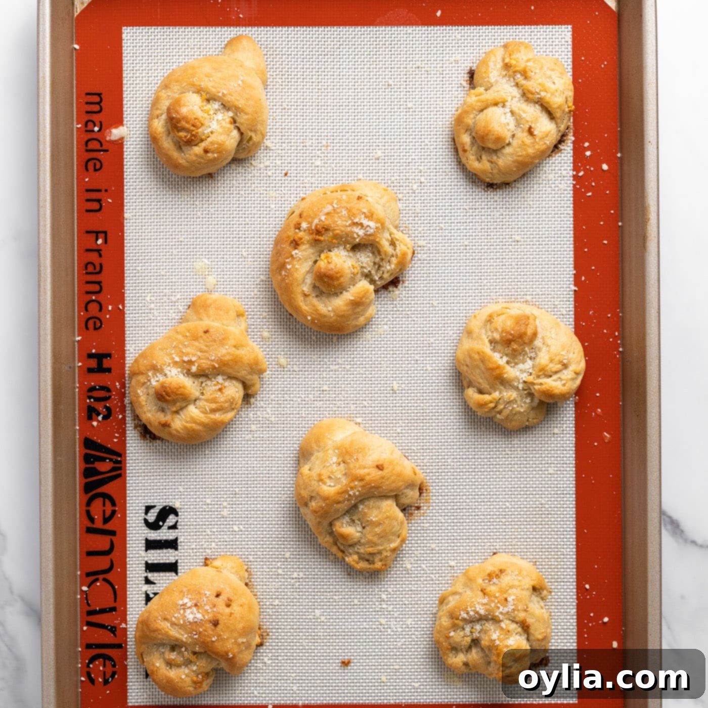 freshly baked parmesan garlic knots on a baking sheet