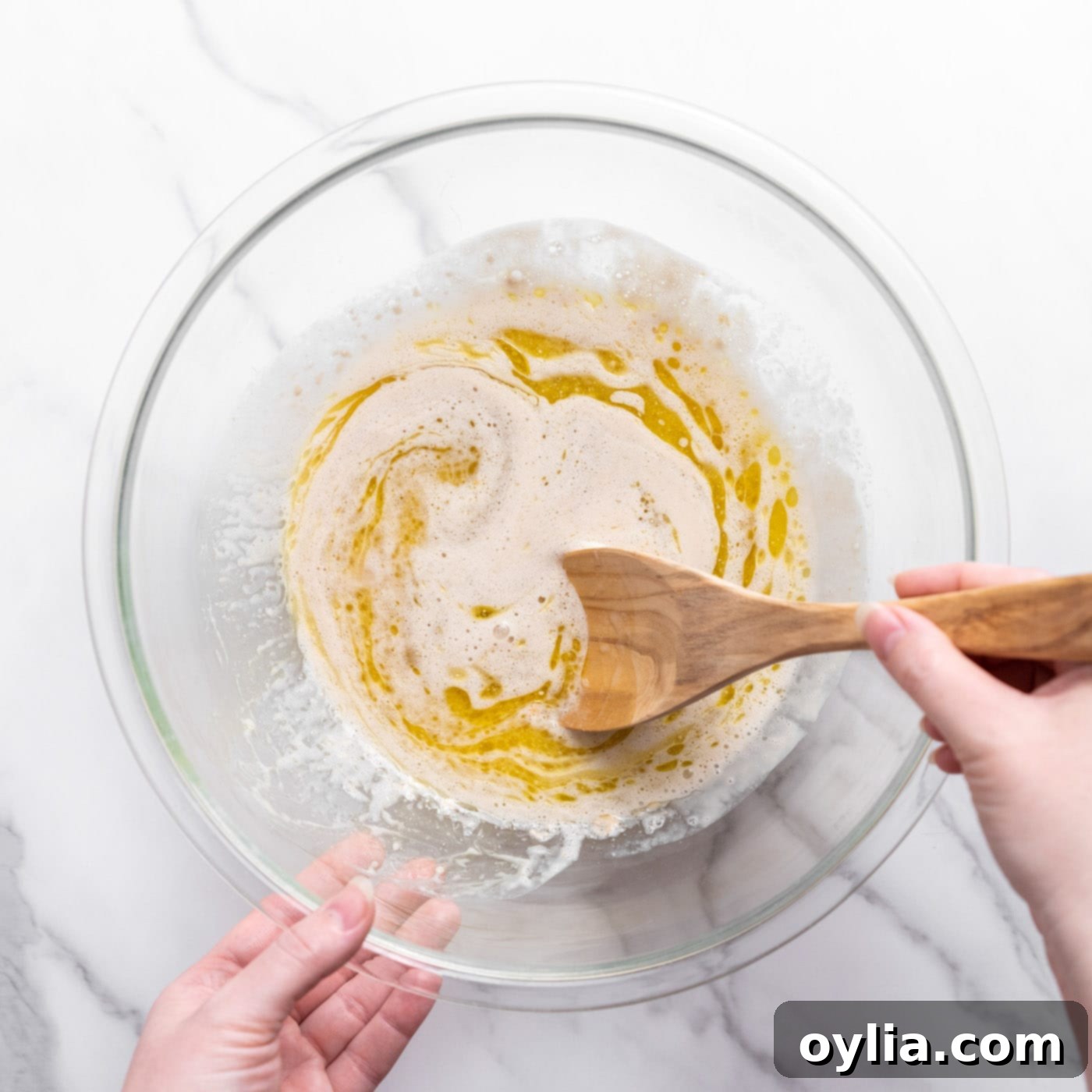 mixing dough ingredients into yeast mixture in a bowl