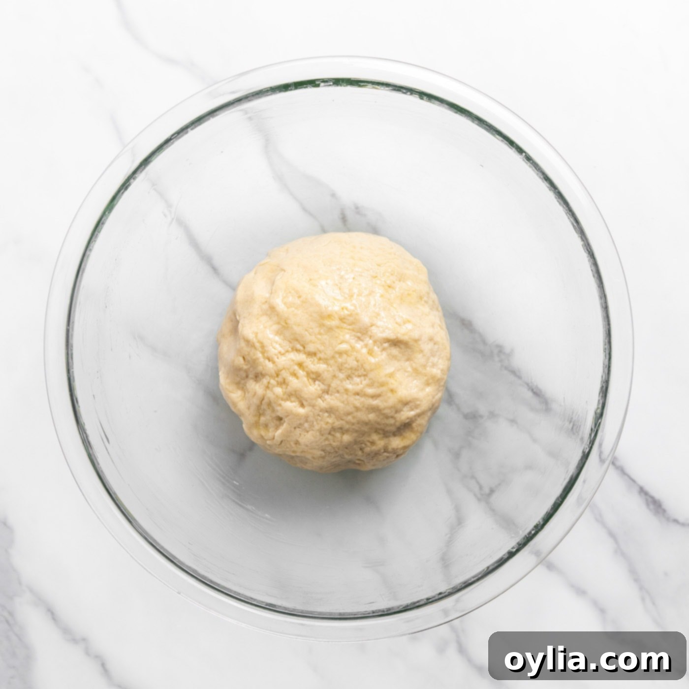 smooth dough ball resting in a mixing bowl