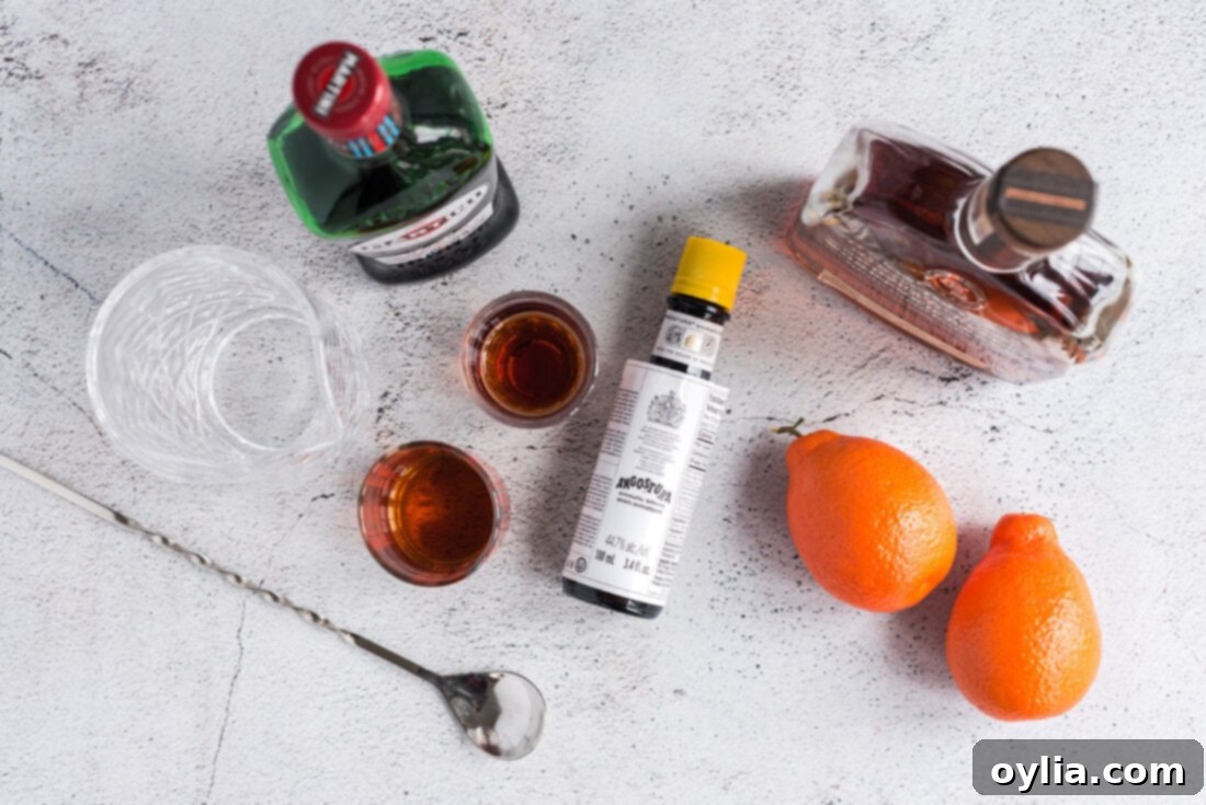 Ingredients laid out for making a Manhattan Cocktail: rye whiskey, sweet vermouth, bitters, and cherries