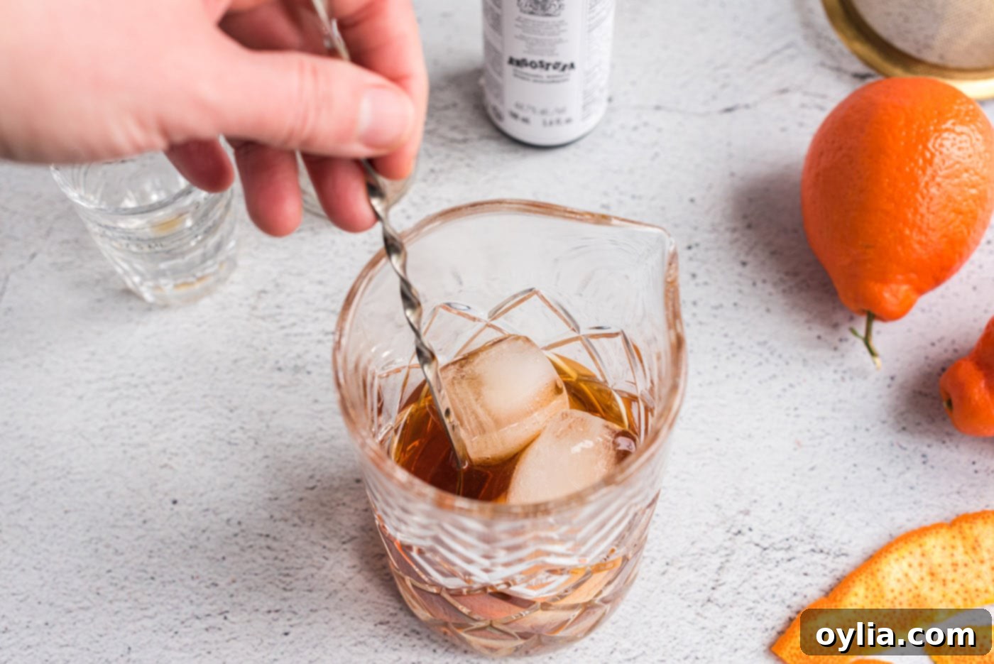Stirring the Manhattan cocktail ingredients with ice in a mixing glass