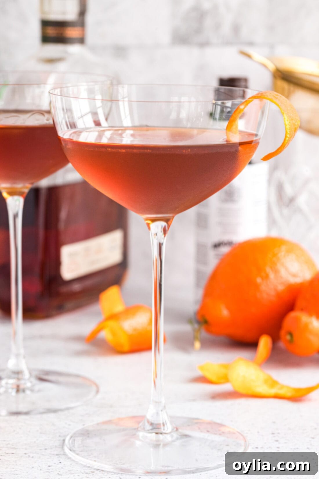 Manhattan Cocktail with bottles of whiskey and vermouth blurred in the background