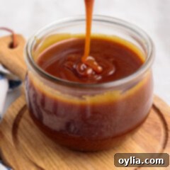 A close-up of creamy caramel sauce, showcasing its smooth texture and rich color, ready to be used in desserts.
