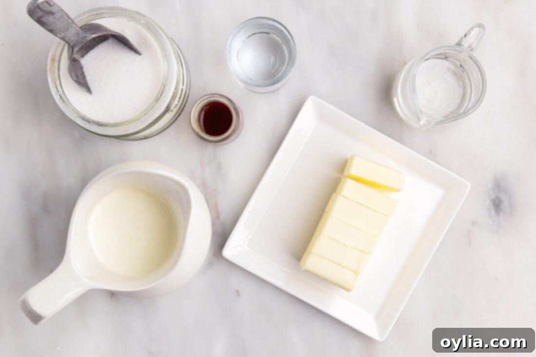 An array of ingredients for homemade caramel sauce: sugar, corn syrup, water, vanilla, heavy cream, and butter.