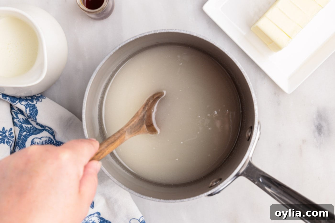 Stirring corn syrup, sugar, and water in a heavy saucepan to combine before heating.