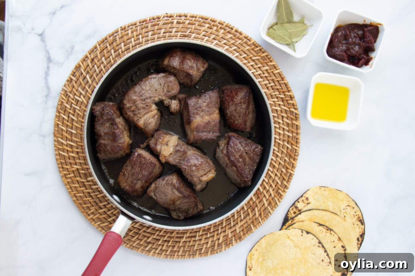 Searing chunks of chuck roast in a hot skillet with olive oil until golden brown on all sides