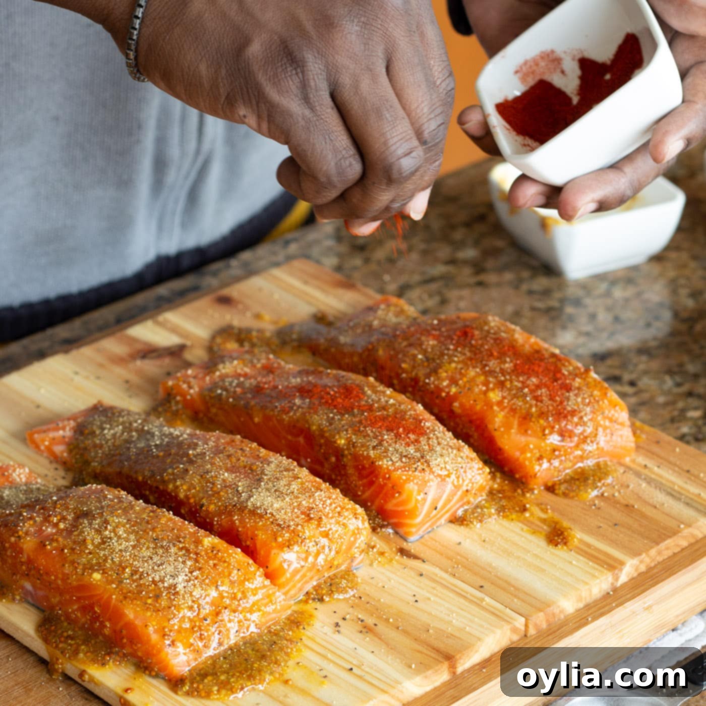 sprinkling paprika onto salmon filets