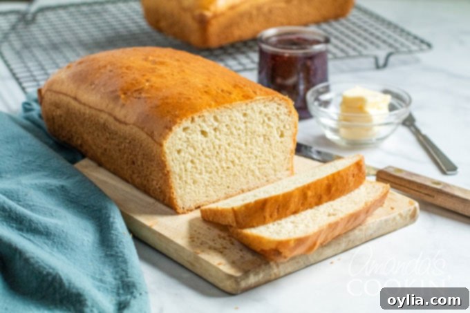 A beautiful loaf of homemade white bread on a wooden cutting board, ready for slicing and enjoying.