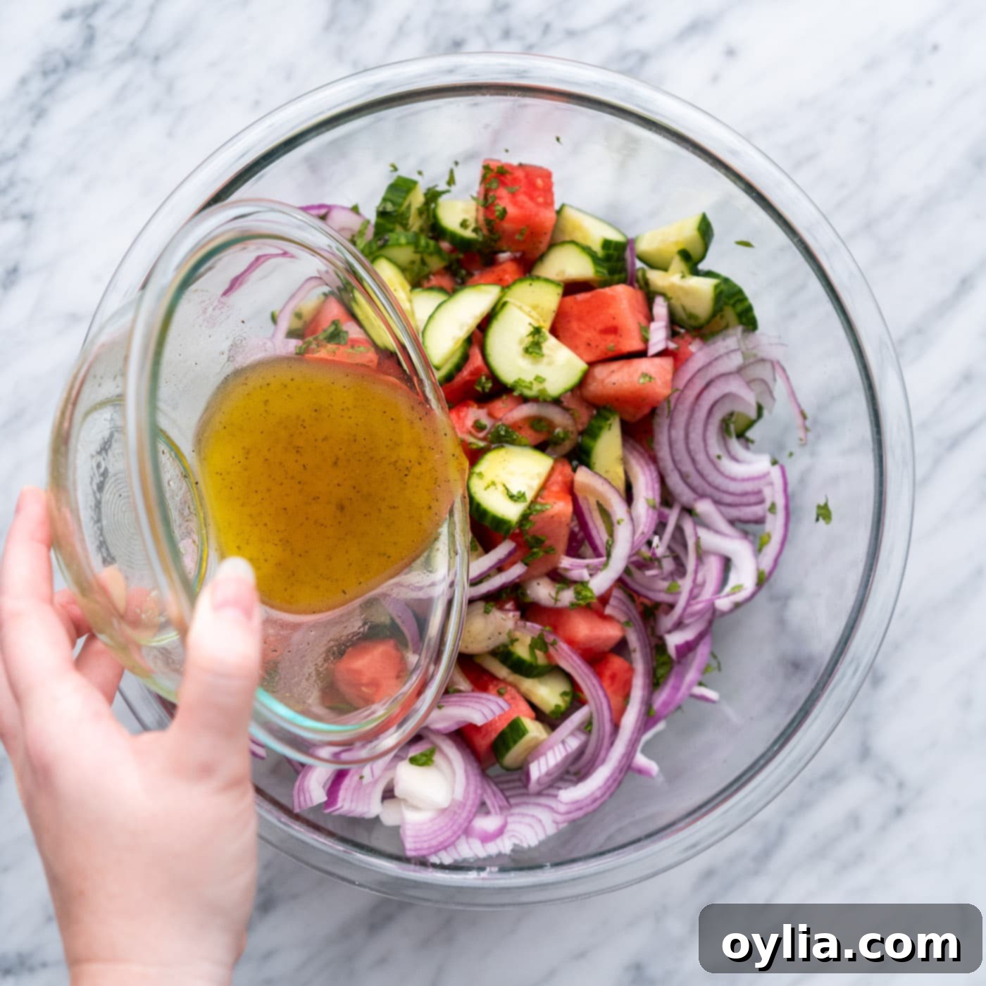 pouring vinaigrette into watermelon salad 