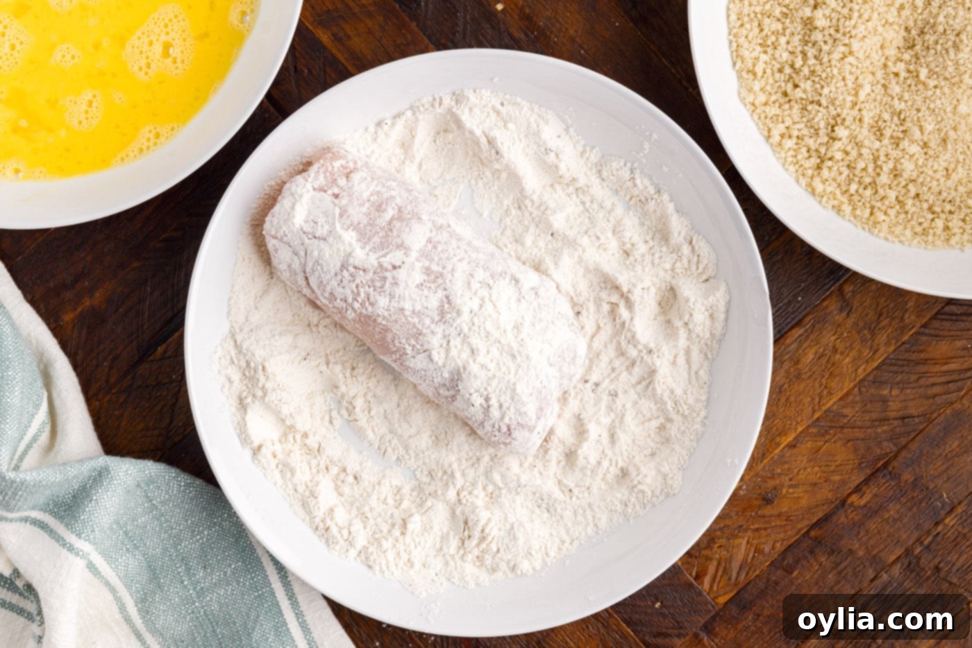 dredging rolled chicken in flour