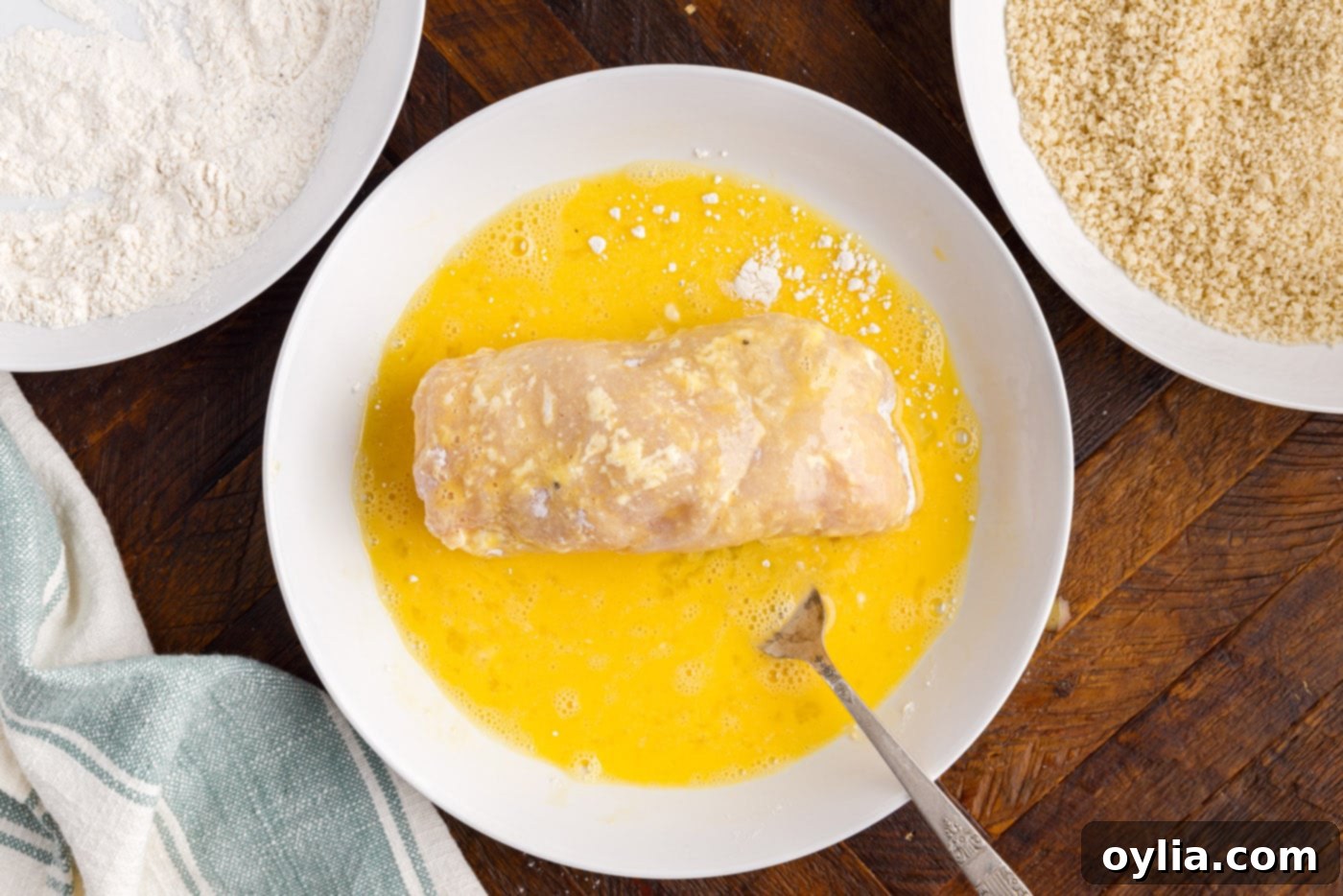 dredging rolled chicken in egg