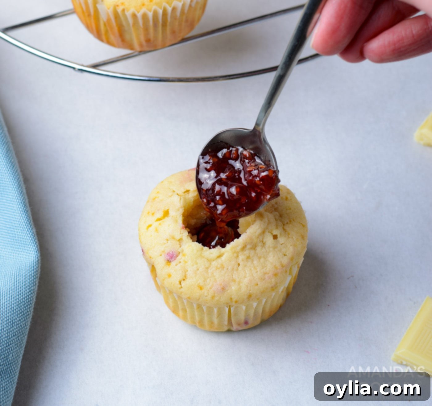filling cupcake with raspberry jam